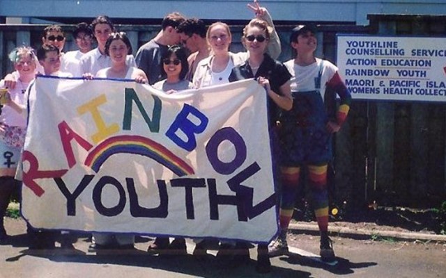 A archive photo of a group of young people holding a Rainbow Youth banner