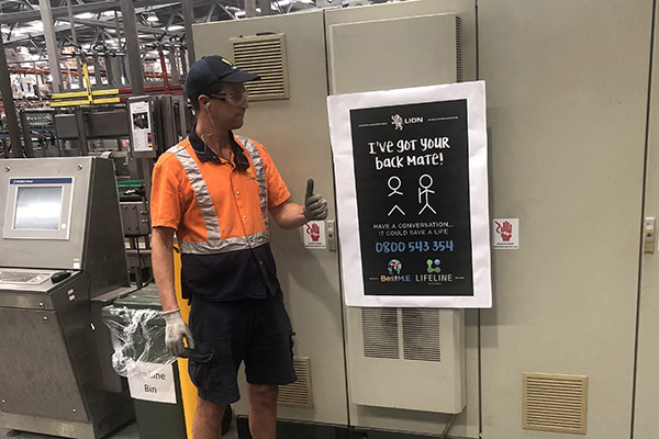 Photo of Lion worker standing beside sign reading I've got your back mate