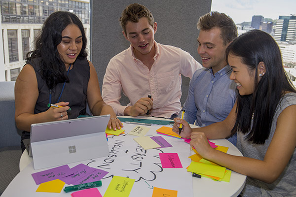 Group of young employees from different ethnic backgrounds work together on a project.