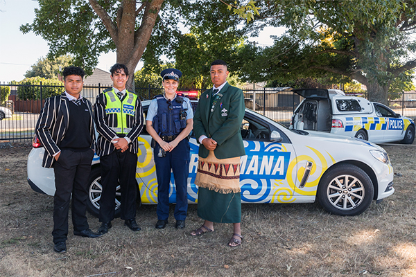 Photo of students and police by police car