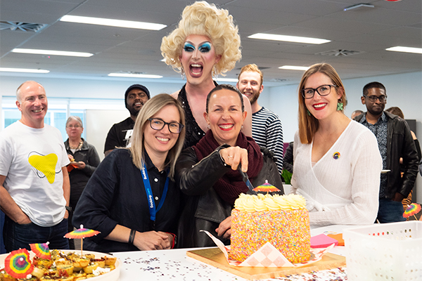 photo of staff with drag queens and rainbow food