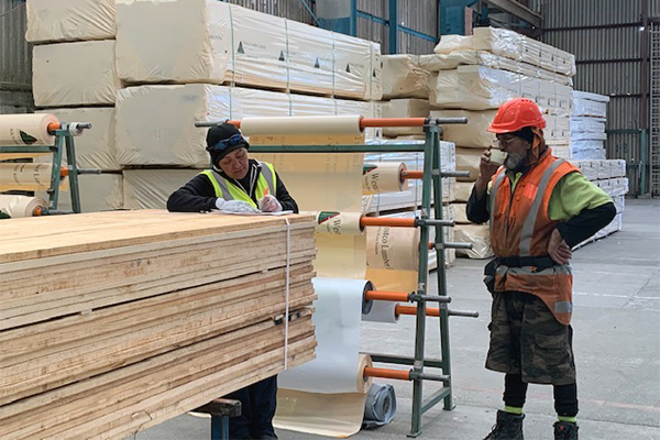 photo of workers writing on lumber