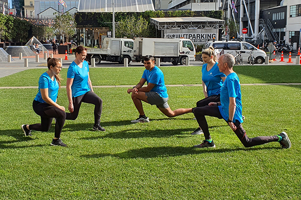 photo of staff doing lunges on lawn