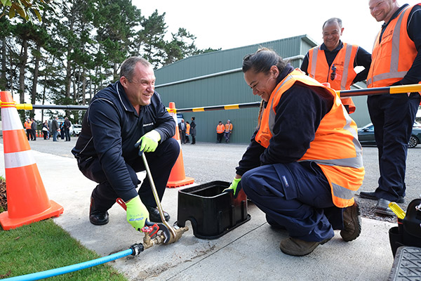 Photo of Citycare team, one woman in high-vis vest and three men working together on training exercise