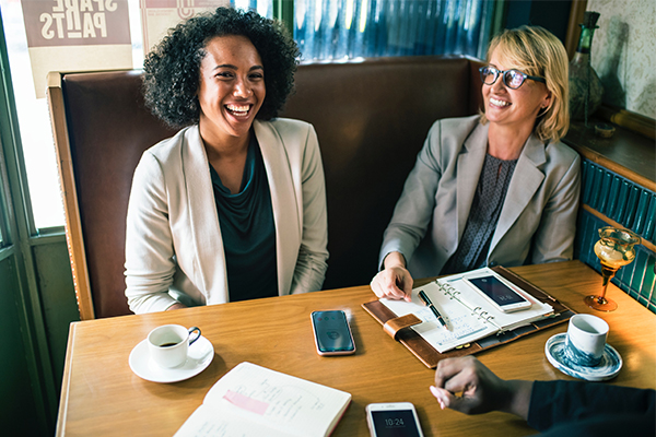 Two women laughing as they work