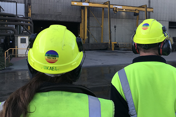 Workers wearing hard hat with we stand together sticker