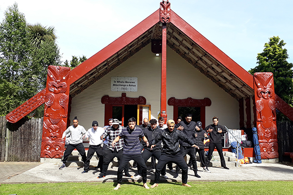 Group doing haka in front of Marae