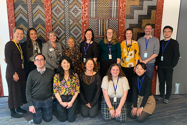 Corporate workers in front of Maori weaving