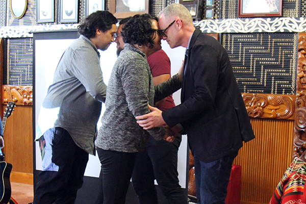 Two sets of people embracing in a hongi