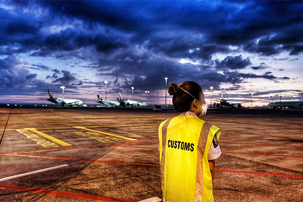 Customs officer looking across tarmac at planes