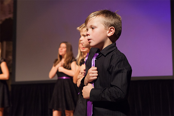 Children's choir performing sign language on stage