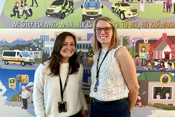 Migrant interns in front of St Johns mural