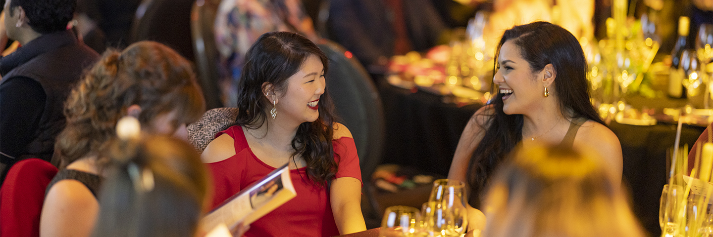 People smiling at table, enjoying the Diversity Awards NZ