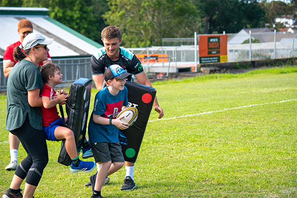 Young kids being helped to play rugby