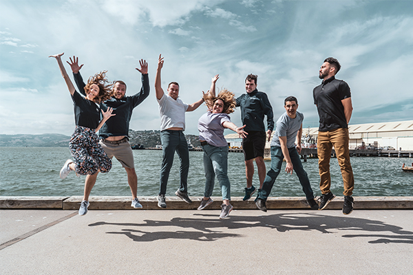 Staff jumping for joy at waterfront