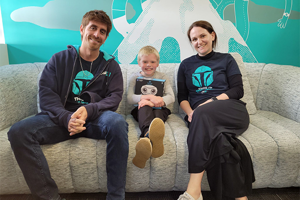 Two LawVu staff sitting with young boy between them