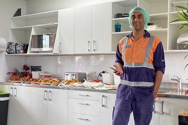 Man in operational baking gear in front of counter full of baking