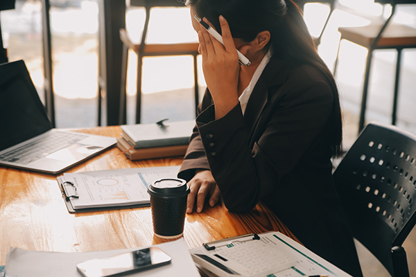 Photo of women at her desk looking distressed